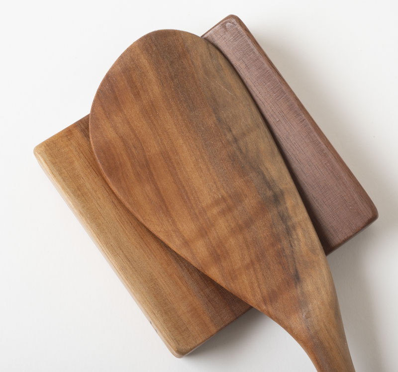 Paddle spatula resting on a spoon rest, in cherry