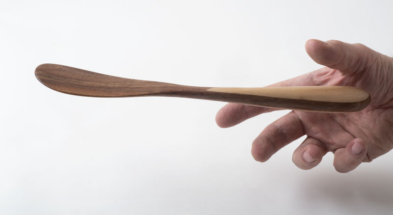 Hand reaching for a Standard Spatula, in cherry and birch